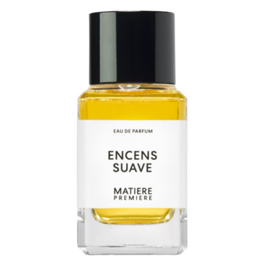 A bottle of Encens Suave perfume with a white label, yellow liquid, and a black cap.
