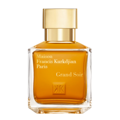 A bottle of Maison Francis Kurkdjian Grand Soir perfume in a clear glass container with a gold-colored cap and label.