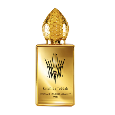 L'Original Lucas 777 perfume A square-shaped perfume bottle with a golden hue and a decorative element resembling a flower at the top. The label includes the text 'Soleil de Jeddah' and 'Stéphane Humbert Lucas 777 Paris'.
